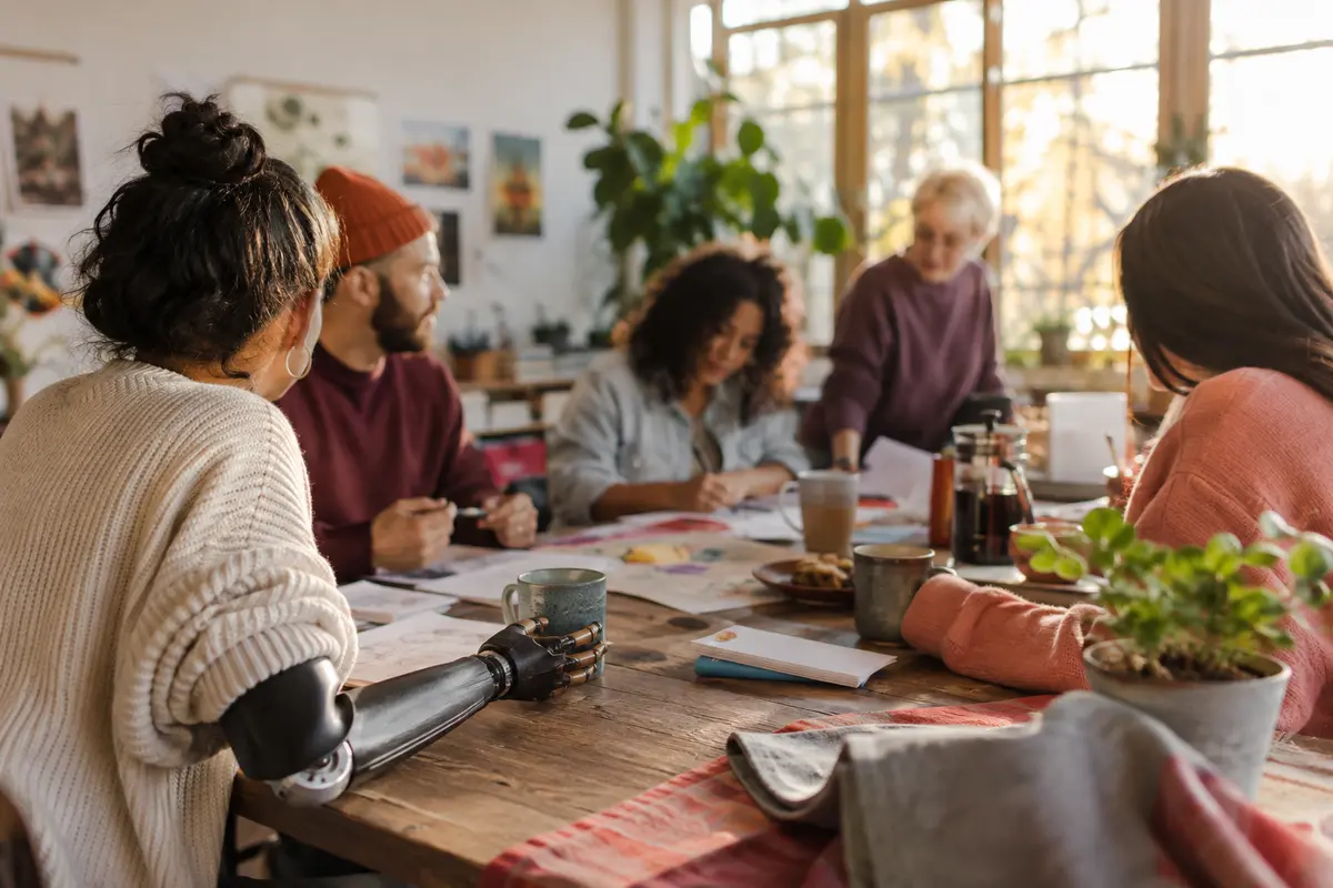 A group of people collaborating around a table in a bright community workshop