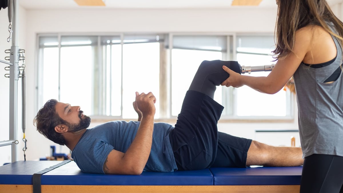 Man and woman engaging in a physical therapy session, focusing on prosthetic leg recovery and rehabilitation.