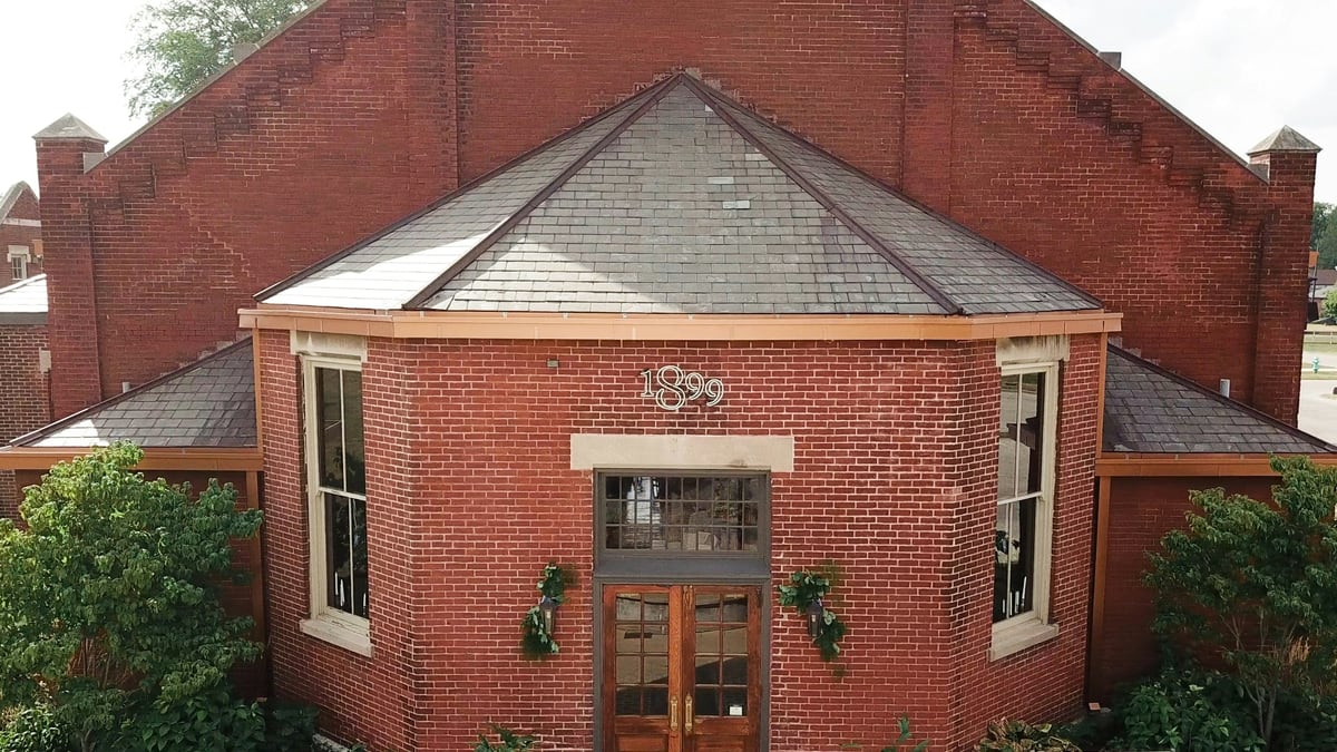 a red brick building with a bench in front of it