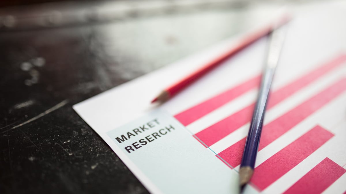 Close-up of market research paper with red graph bars and pencils, emphasizing business analysis.