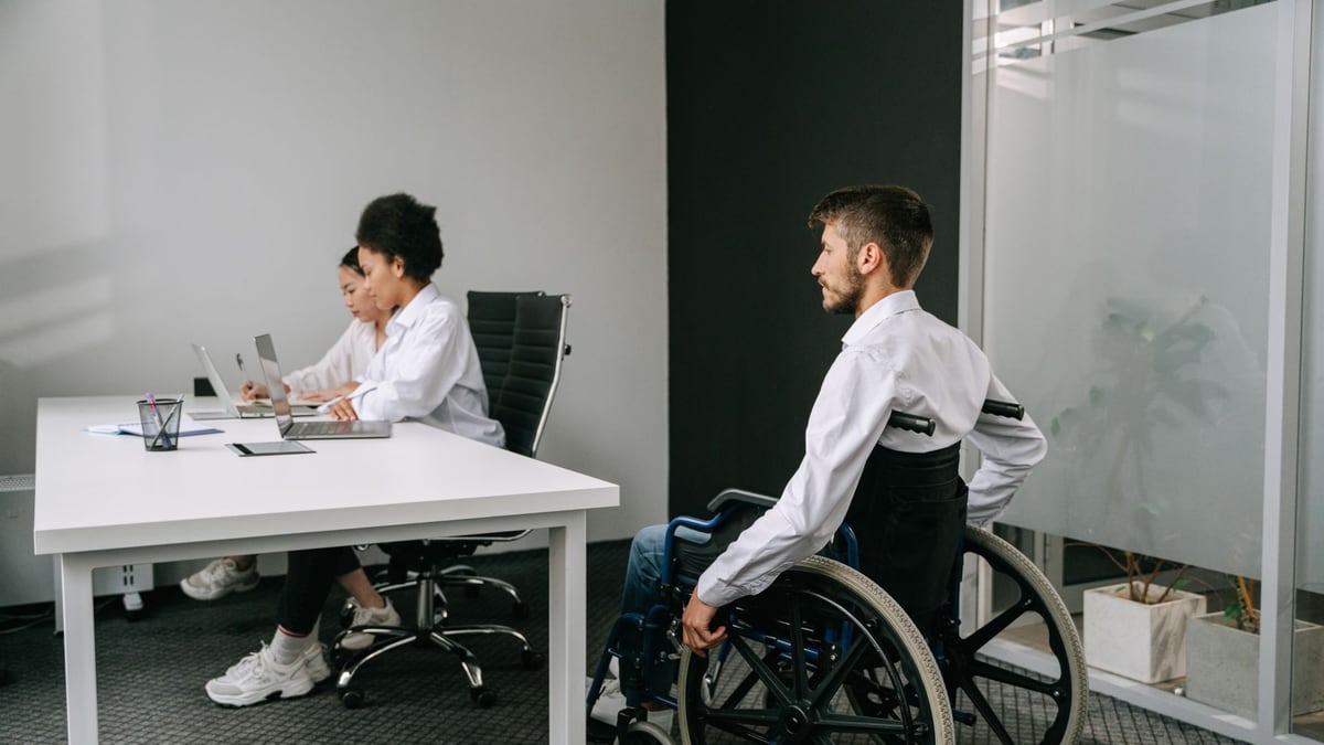 Diverse team in an office meeting, focusing on inclusive workplace and accessibility.